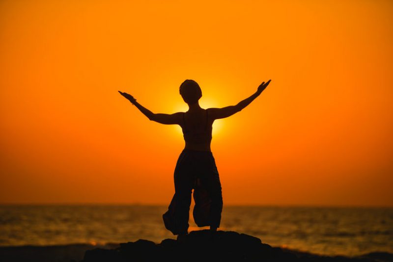 51786420 - female meditates during yoga and opens her body to the sun at a sunset